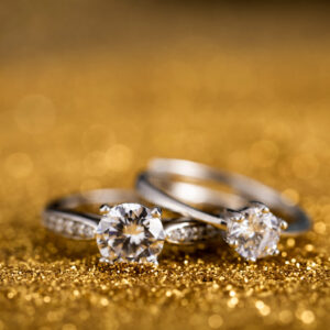 Home closeup shot of two diamond rings on a golden surface